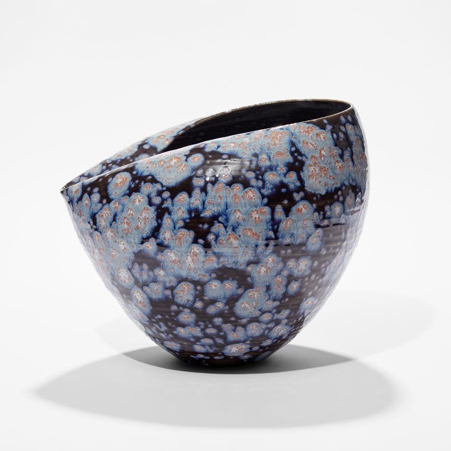 rounded vase with collapsed inverted top section in dark black blue with light blue white and pink starburst splodges hand thrown and glazed from ceramic