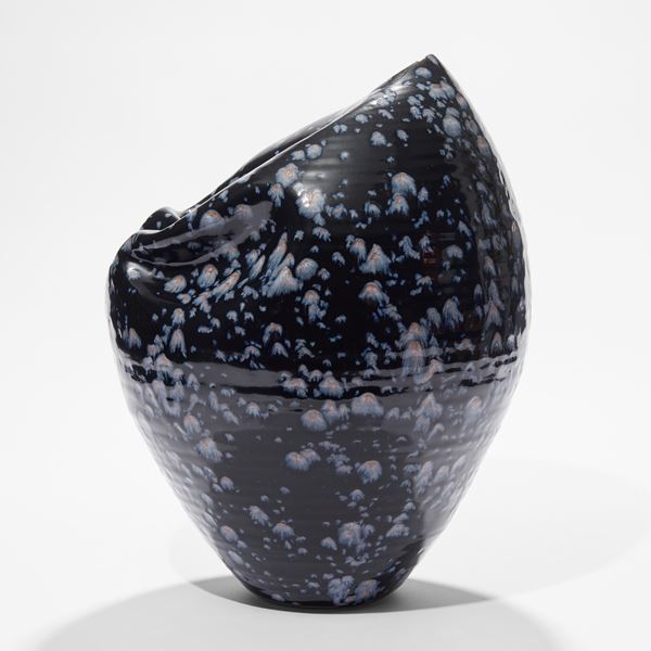 black blue with light blue splodges tapered based rounded vessel with wrinkled lightly collapsed side and opening hand made from ceramic