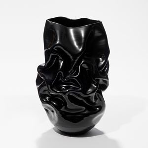 ceramic shiny black crumpled and wrinkled vase with rounded base and uneven top opening lip hand made from white st thomas glazed clay