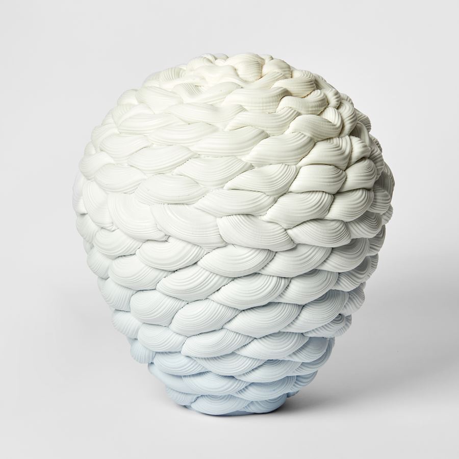inverted teardrop shaped vessel with the appearance as if knitted with thick ridged yarn fading from light blue at the base to white at the top hand made from parian porcelain