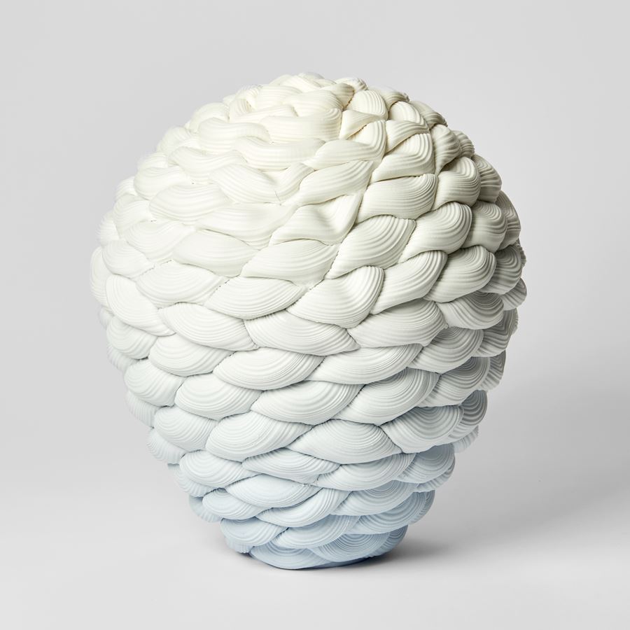 inverted teardrop shaped vessel with the appearance as if knitted with thick ridged yarn fading from light blue at the base to white at the top hand made from parian porcelain