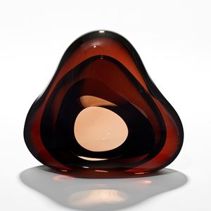 brilliant transparent rich dark amber brown amorphous sculpture with central front facing organic opening hand made from glass