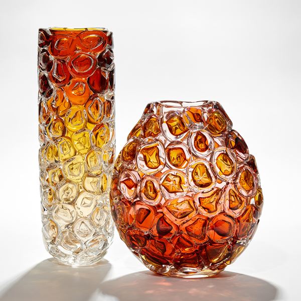 cylindrical vase fading upwards from clear yellow to amber appearing as if made from stacked oversized bubbles handmade from glass