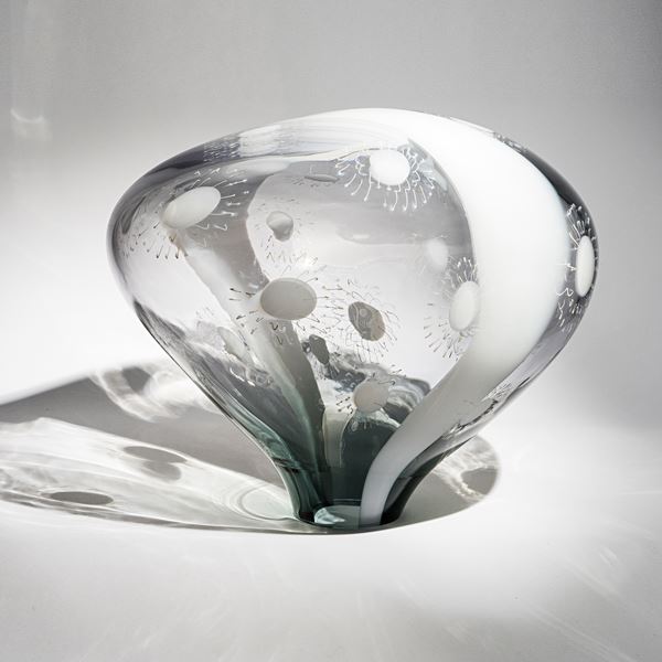 transparent grey and opaque white simplified mushroom shaped sculpture with stripe and dot patterns hand made from glass