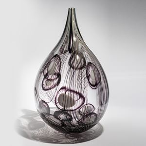 transparent grey and aubergine teardrop shaped vessel with fine lines and abstract circle patterns in dark aubergine handmade from glass