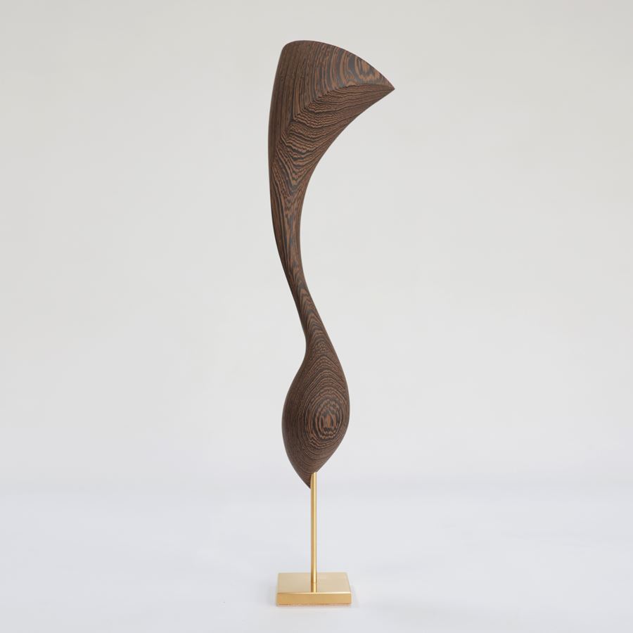 curled wooden sculpture created from Wengé with gold inlaid detail and a flared fan shaped top long slender neck and round base perched on a gold plated stainless steel base