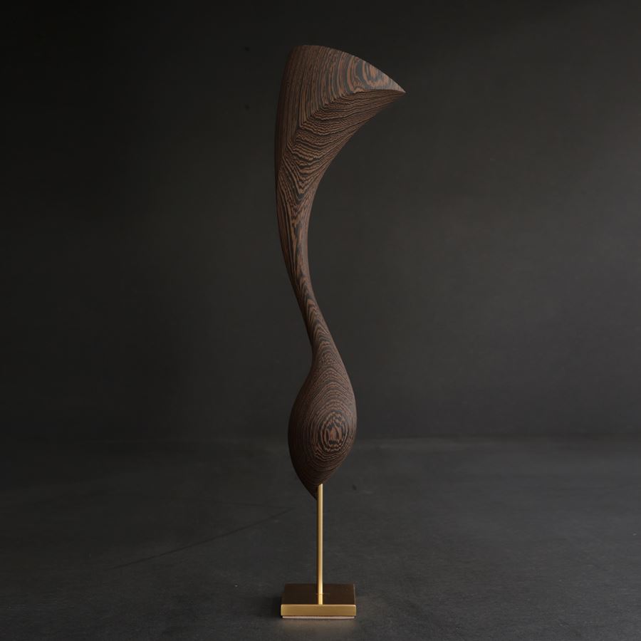 curled wooden sculpture created from Wengé with gold inlaid detail and a flared fan shaped top long slender neck and round base perched on a gold plated stainless steel base