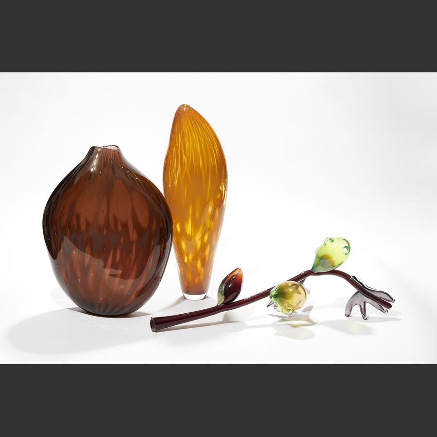 abstract branch with fruits and leaves in brown yellow green and red hand sculpted from glass