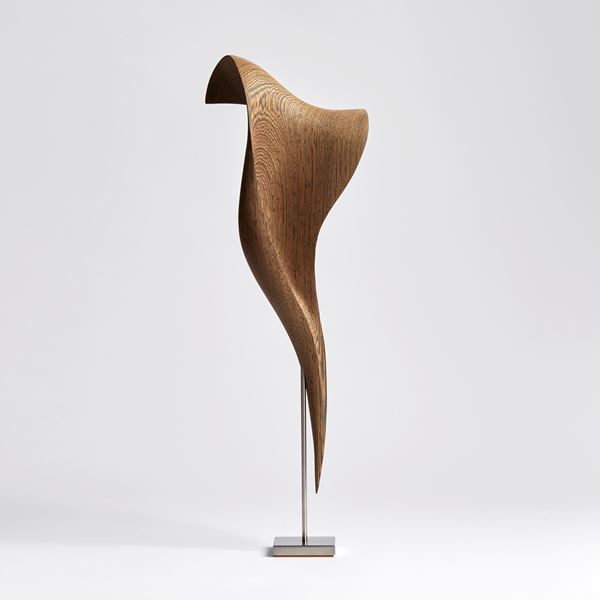curled Wengé wood sculpture with the appearance of a fluttering and falling piece of silk with patterned wood grain texture on stainless steel stand