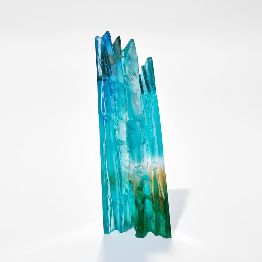 cast glass sculpture resembling a cliff face in jade turquoise blue clear and fawn with two polished outer surfaces and two inner highly textured surfaces