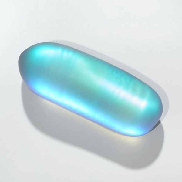 purple top and grey bottom elongated lozenge shaped pebble with satin smooth surface with inner turquoise glowing colour hand made from cast glass