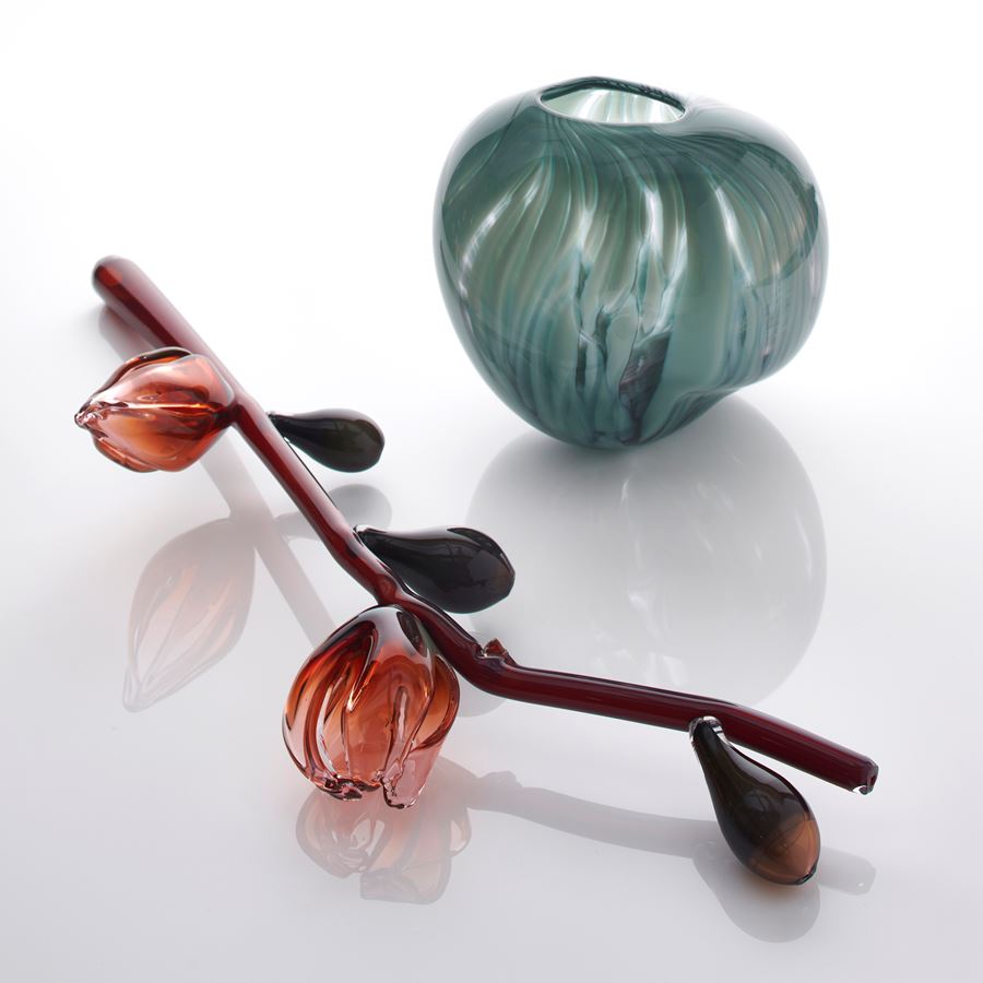 prone oxblood red stem with abstract flowers and buds in pink red and celadon hand made from sculpted glass