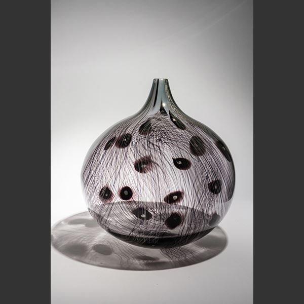 transparent grey and dark aubergine rounded bottle with elongated neck with fine organic cane pattern and dots hand made from glass