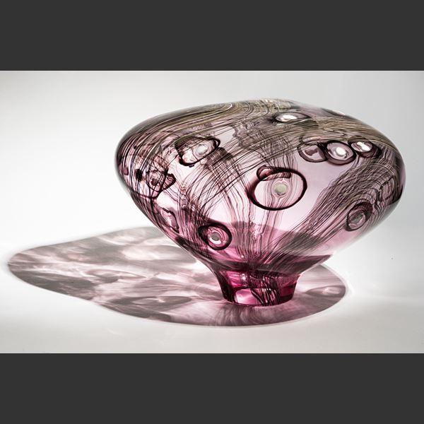 smooth surfaced simplified mushroom shaped sculpture handmade from pink transparent glass with dark aubergine line and circle patterns with white dots