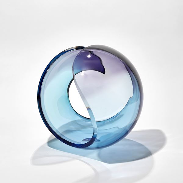 transparent curled glass sculpture in the form of a stylised shell in turquoise and purple hand made from glass