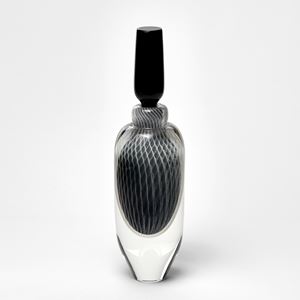 tall elegant round clear bottle with tapered base and long black stopper with fine filigree pattern trapped within hand made from glass