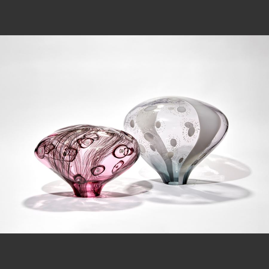 transparent grey and opaque white simplified mushroom shaped sculpture with stripe and dot patterns hand made from glass