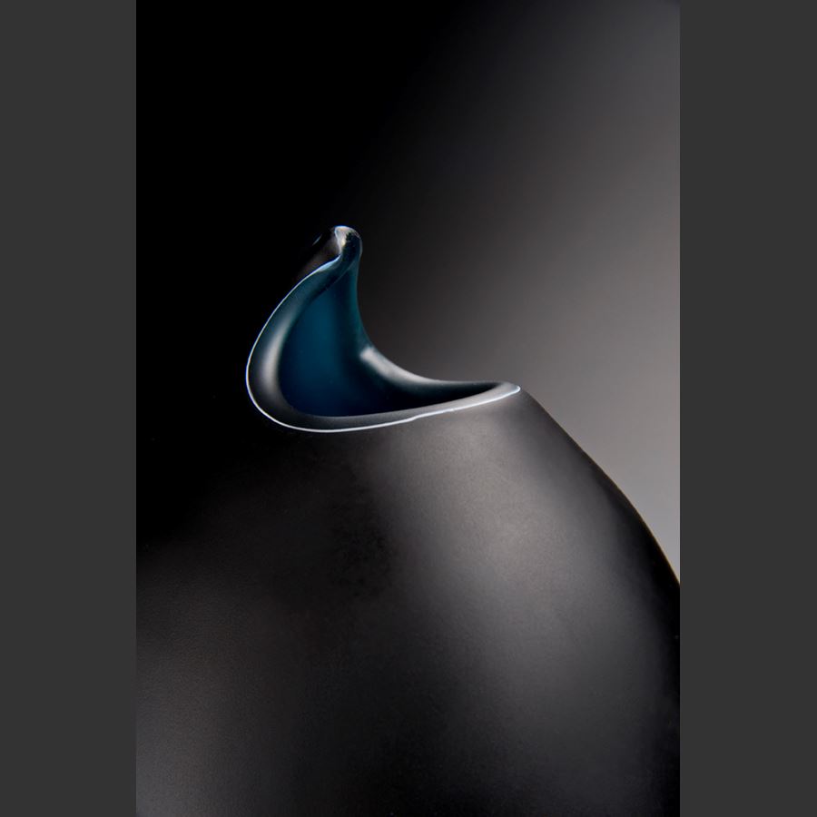 modern art glass sculpture of a fish in black with blue scales