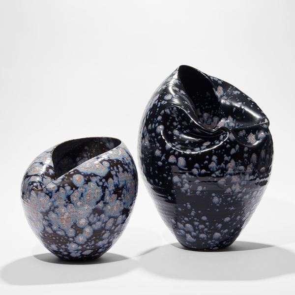 black blue with light blue splodges tapered based rounded vessel with wrinkled lightly collapsed side and opening hand made from ceramic