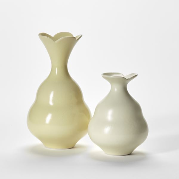 pair of soft pastel yellow vases with beehive shaped bases and flared necks and tops with floral scalloped edges