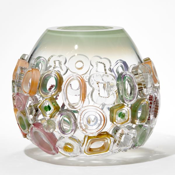 hand blown rounded bowl in clear glass with faded tapering soft jade top edge covered in differently shaped glass murrini rings in various pastel colours 