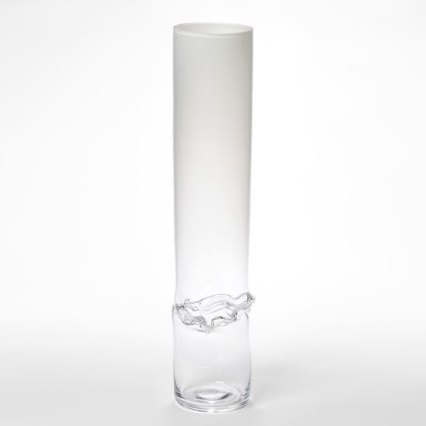 hand blown tall glass hollow column with clear lower half fading to opaque white upper section with waist section that flares and ripples