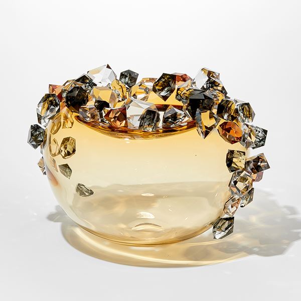 round light amber gold round transparent bubble covered in oversized irregular shaped gem stones in amber grey and clear with some with inky swirls trapped within handmade from glass
