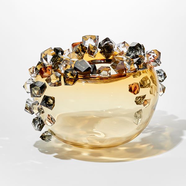 round light amber gold round transparent bubble covered in oversized irregular shaped gem stones in amber grey and clear with some with inky swirls trapped within handmade from glass