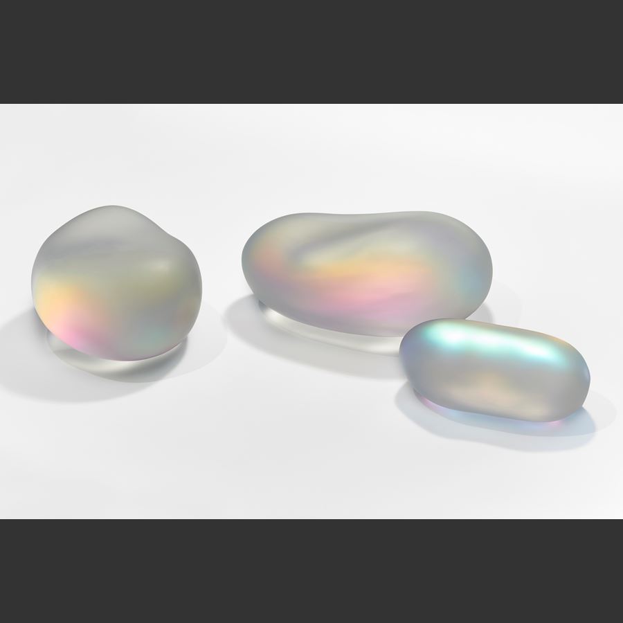 shimmering glass amorphic pebble rock sculpture with inner myriad of colours with the appearance as if emitting light from within hand made from blown and sculpted glass