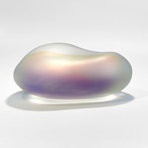 large smooth surfaced rock sculpture made from cast opaque glass with a trapped film inside giving off the effect of dragonfly wing colours creating a shimmering rainbow of all different hues