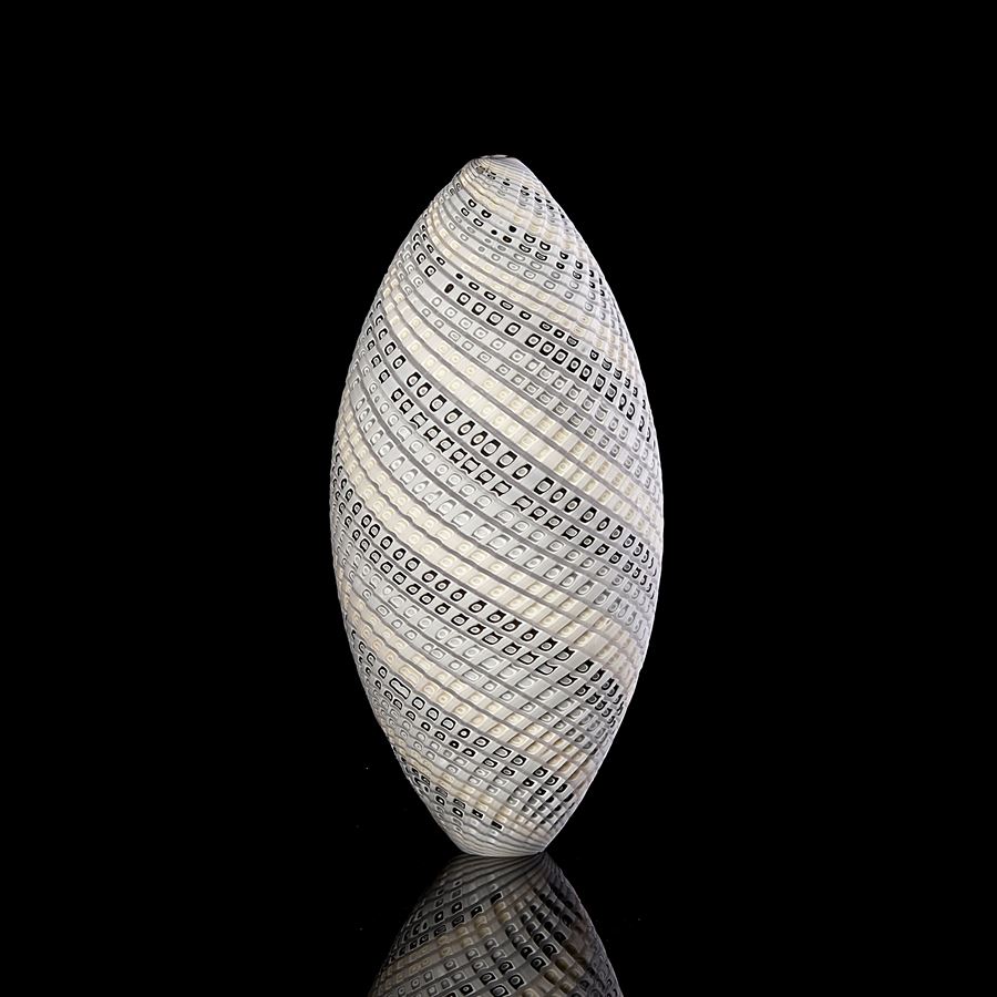 standing ovoid shaped vessel in off white cream and grey with curling lines of colour twisting round the piece and cut texture on the surface hand made from glass