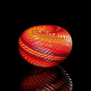 round textured orange yellow and aubergine purple striped vessel with central dipped opening with straight cut recessed lines swirling around the piece hand made from glass