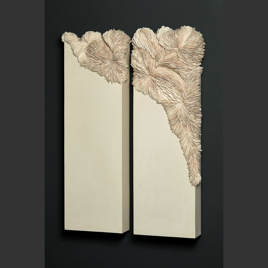 ivory off white cream twinned wall mounted rectangular artworks with traversing textured section with embedded shards traversing from one panel to the other in an organic spread hand made from porcelain and tadelakt plaster