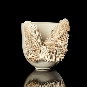 ivory coloured round bowl with tall sides and front third cut away with the gap filled with stacked shards hand made from porcelain