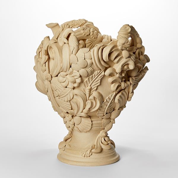 flared light biscuit coloured vase with dramatic architectural swirls flourishes shells and floral details with undulated top edge hand made from white saint thomas clay