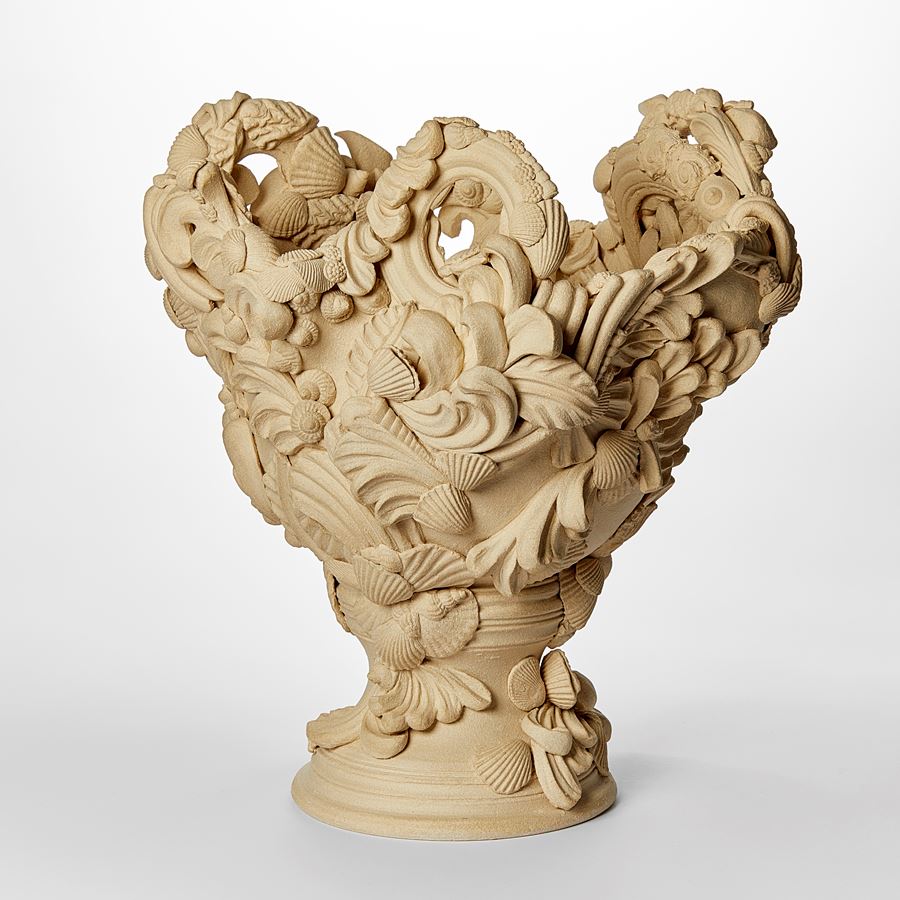 flared light biscuit coloured vase with dramatic architectural swirls flourishes shells and floral details with undulated top edge hand made from white saint thomas clay