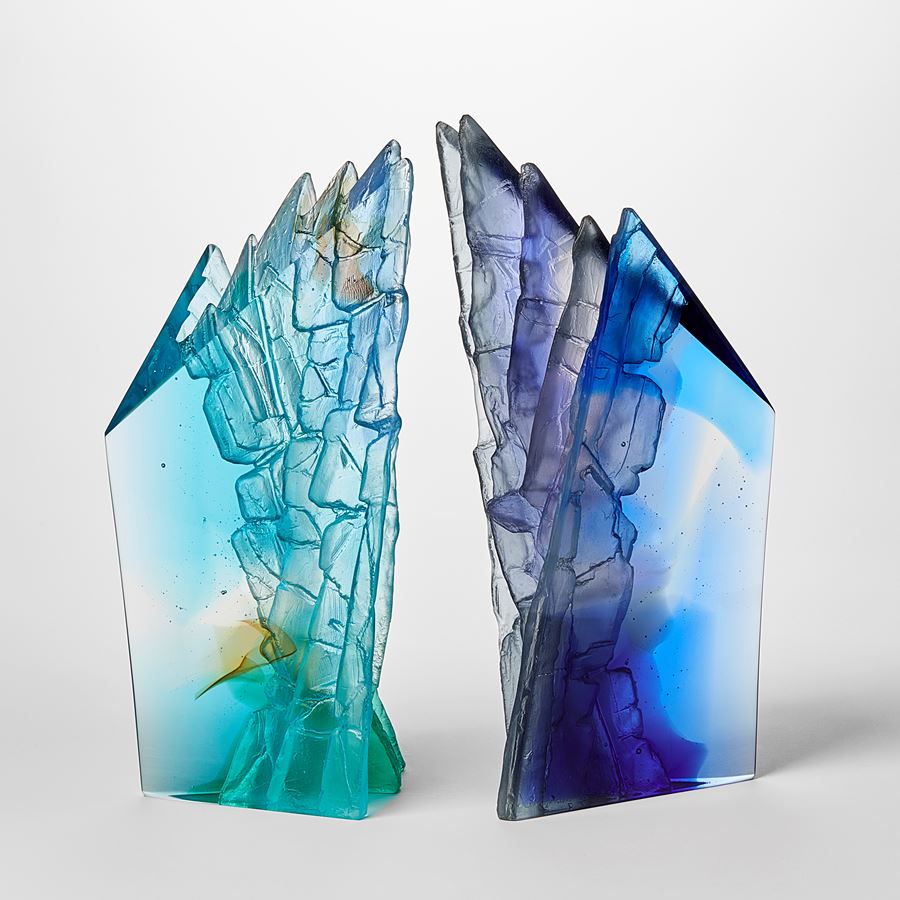 mixed blues cast glass sculpture inspired by rocky cliff edges with angular form and two polished sides with two additional sides covered with intense rough detail
