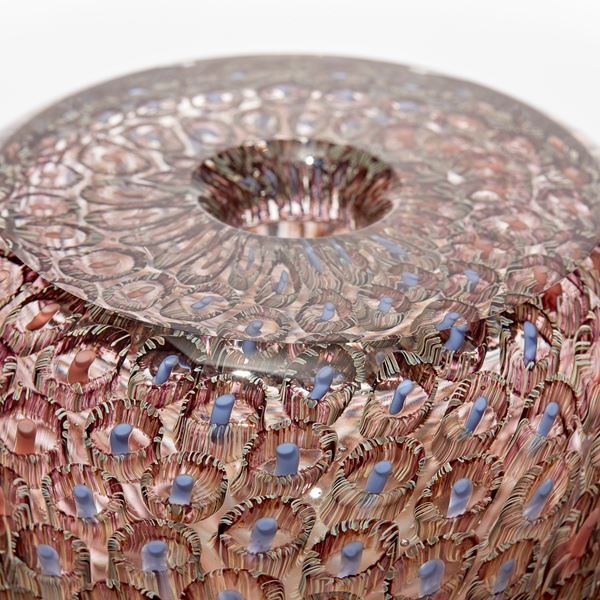 transparent round vessel with flat top and small opening with intense fine repeating murrine pattern in coral salmon aubergine and blue hand made from glass