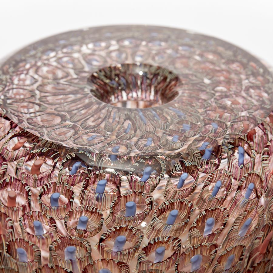 transparent round vessel with flat top and small opening with intense fine repeating murrine pattern in coral salmon aubergine and blue hand made from glass
