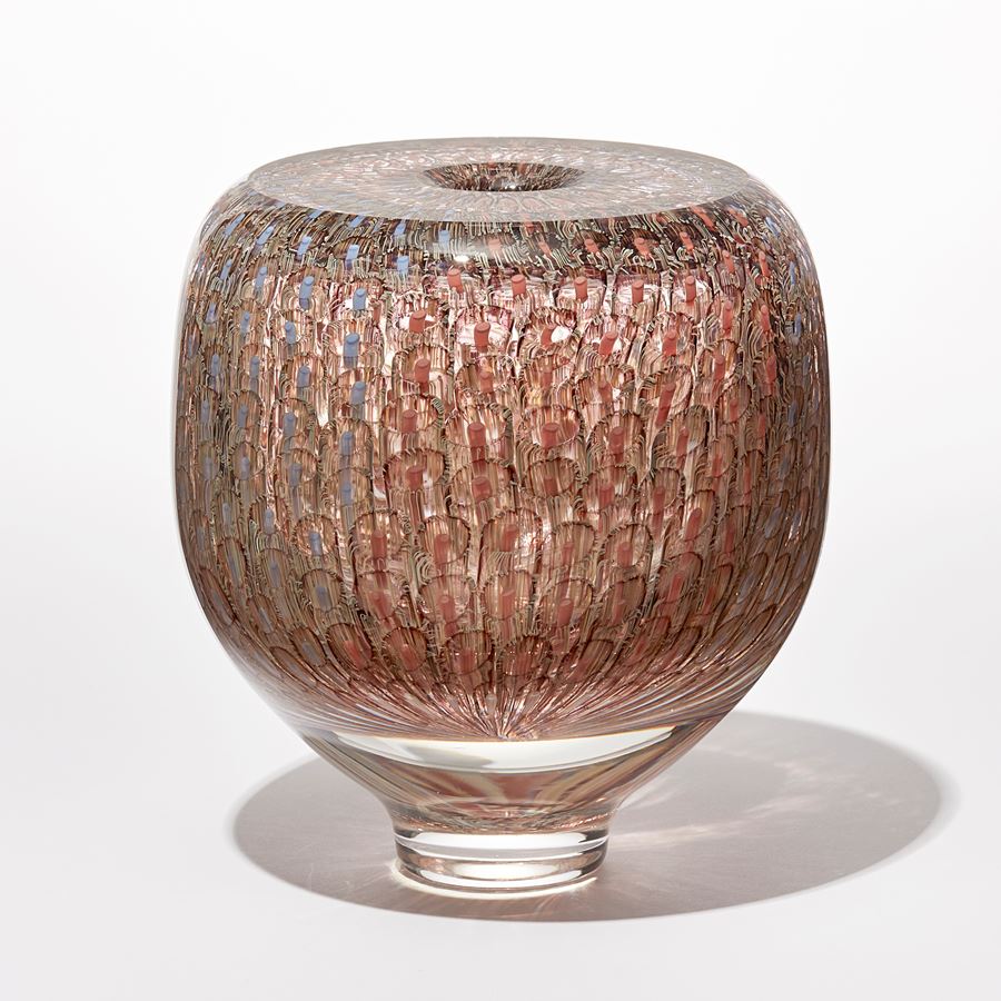 shiny transparent heavy vase with flat top and small central aperture covered in a fine delicate organic repeat swirling line pattern in aubergine salmon coral and pale blue hand made from glass