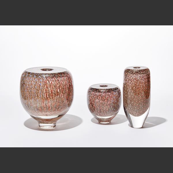 shiny transparent heavy vase with flat top and small central aperture covered in a fine delicate organic repeat swirling line pattern in aubergine salmon coral and pale blue hand made from glass
