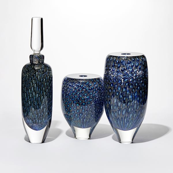 transparent rounded vessel with tapered base with flat top and central opening covered in an intense detailed pattern in rich blue turquoise and aquamarine hand made from glass