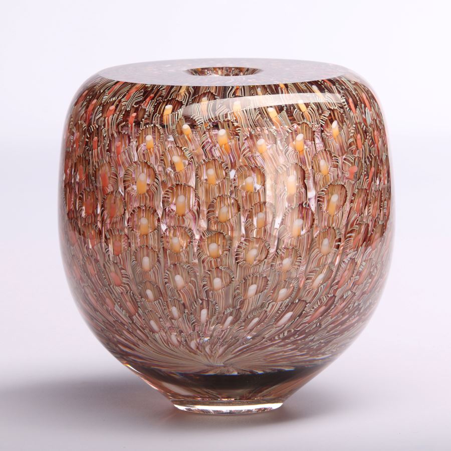 salmon aubergine and soft yellow finely patterned low round vessel with tiny aperture opening in the middle of a flat top hand made from glass
