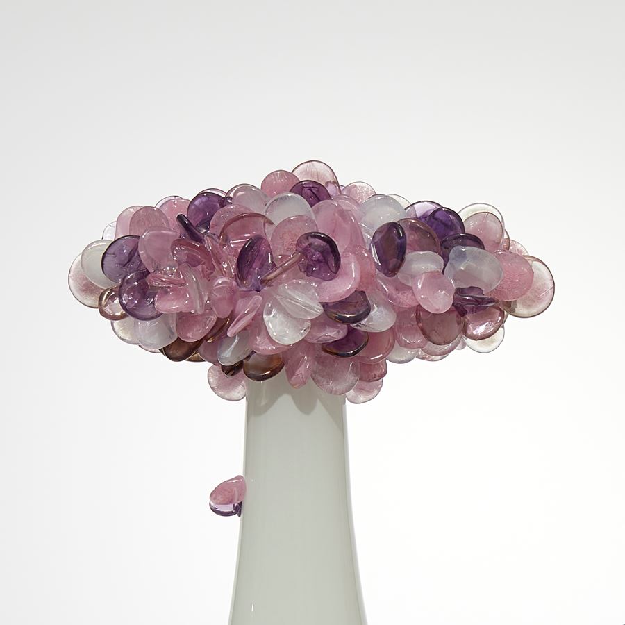 a trio of abstract trees each with an sleek alabaster coloured trunk topped with a multitude of sugary candy cane pink coloured lolliop leaves hand made from glass and presented on a rectangular wooden base