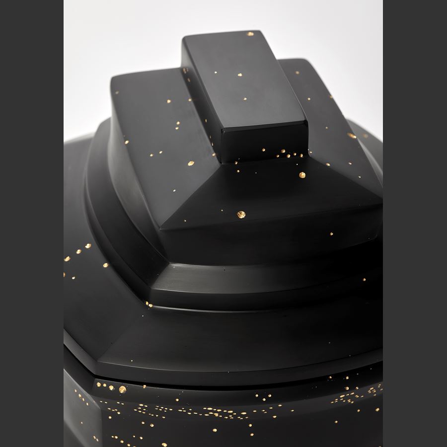 dense black box with facetted and angled sides and lid with randomly arranged recessed small holes all over the surface filled with 23.5 carat gold hand made from cast glass