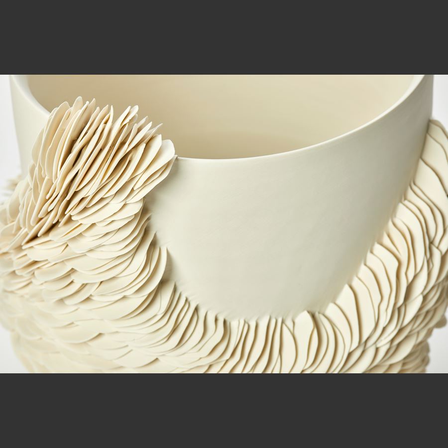 round high sided off white alabaster coloured bowl with exterior organic repeated decorative texture made up of hundreds of scale like shards encircling the main form and reaching the rim in two places hand made from thrown and sculpted porcelain 