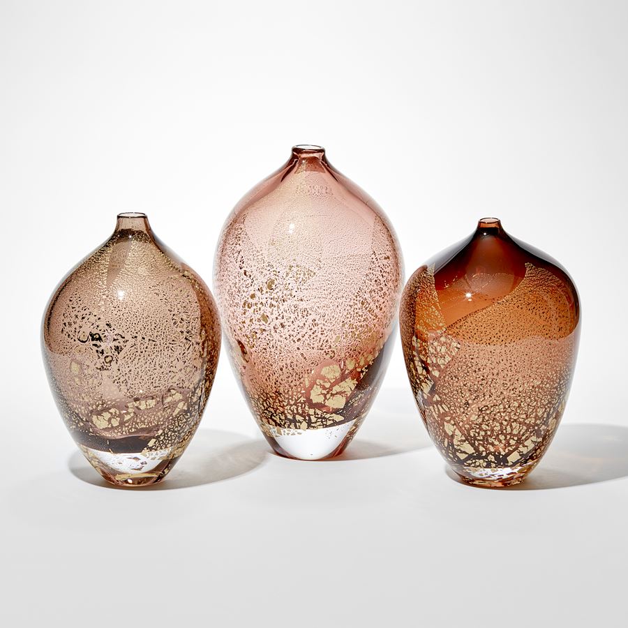 art glass sculptural vases in amber and aubergine with gold leaf-shaped speckles on exterior
