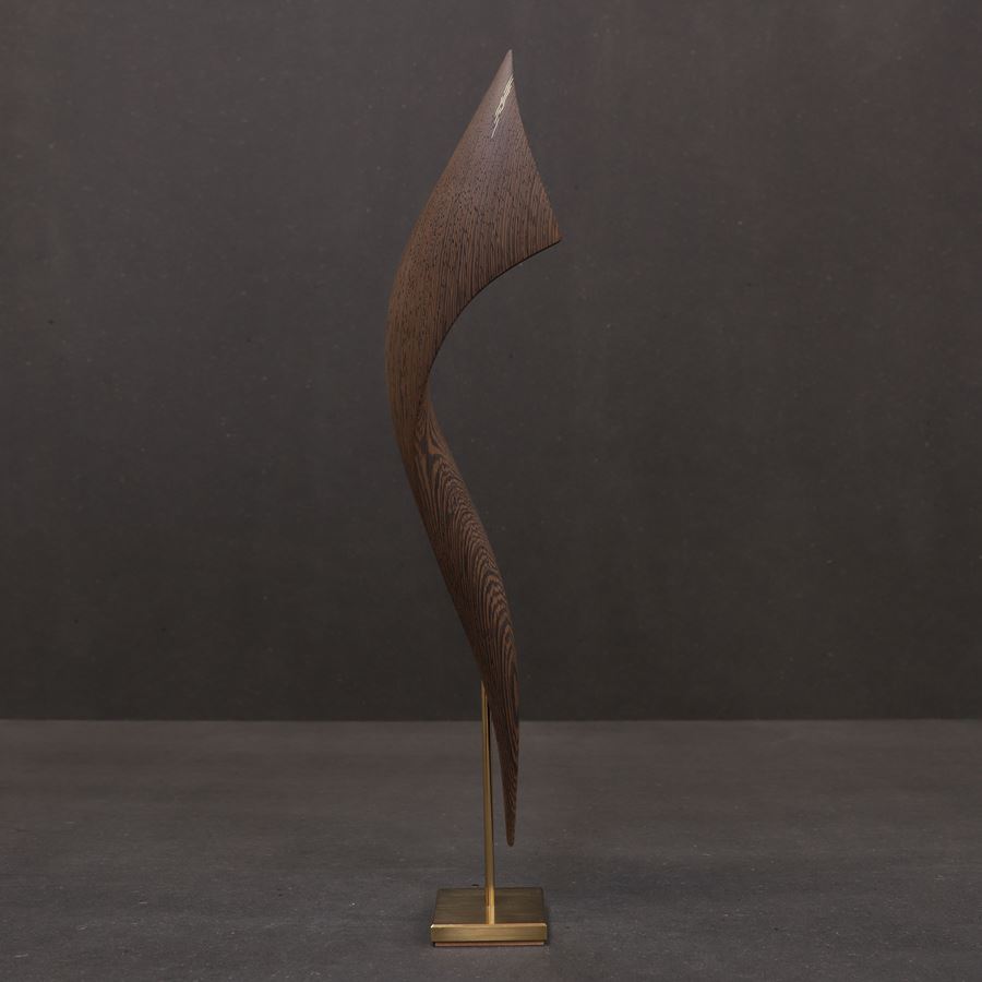 elegant richly grained wenge wood curved sculpture held aloft on a gold plated stand with fine gold inlaid detail