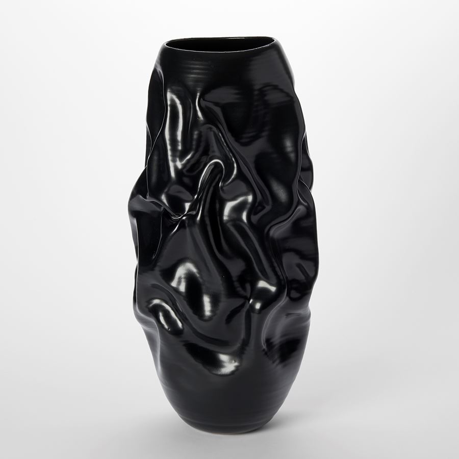 tall satin black crumpled and wrinkled abstract vessel with distinct surface lines and crevasses hand made and thrown from clay