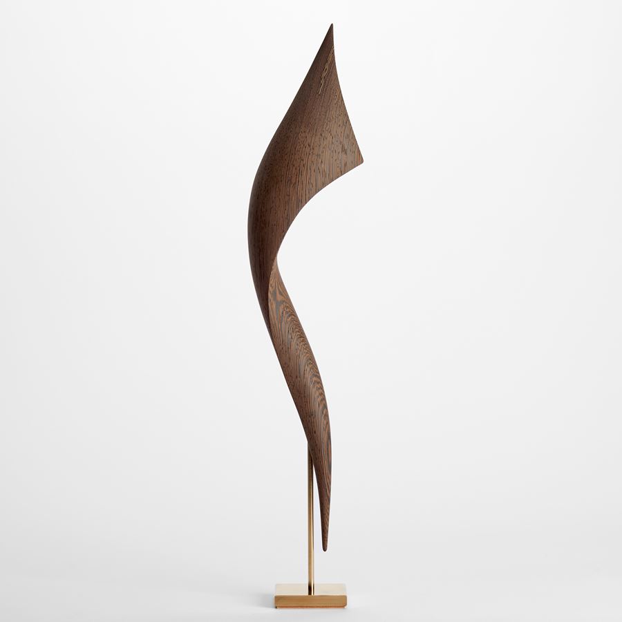 elegant richly grained wenge wood curved sculpture held aloft on a gold plated stand with fine gold inlaid detail